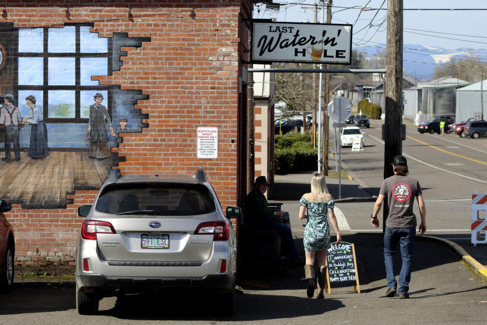 FILE - Customers walk toward the Last Waterin' Hole restaurant in North Plains, Ore., on March 17, 2023. In an attempt to attract semiconductor companies to Oregon, the state Legislature on Thursday, April 6, 2023, authorized the governor to expand urban growth boundaries to provide land for chip makers to build factories and provides over $200 million in grants to chipmakers. (AP Photo/Andrew Selsky, File)