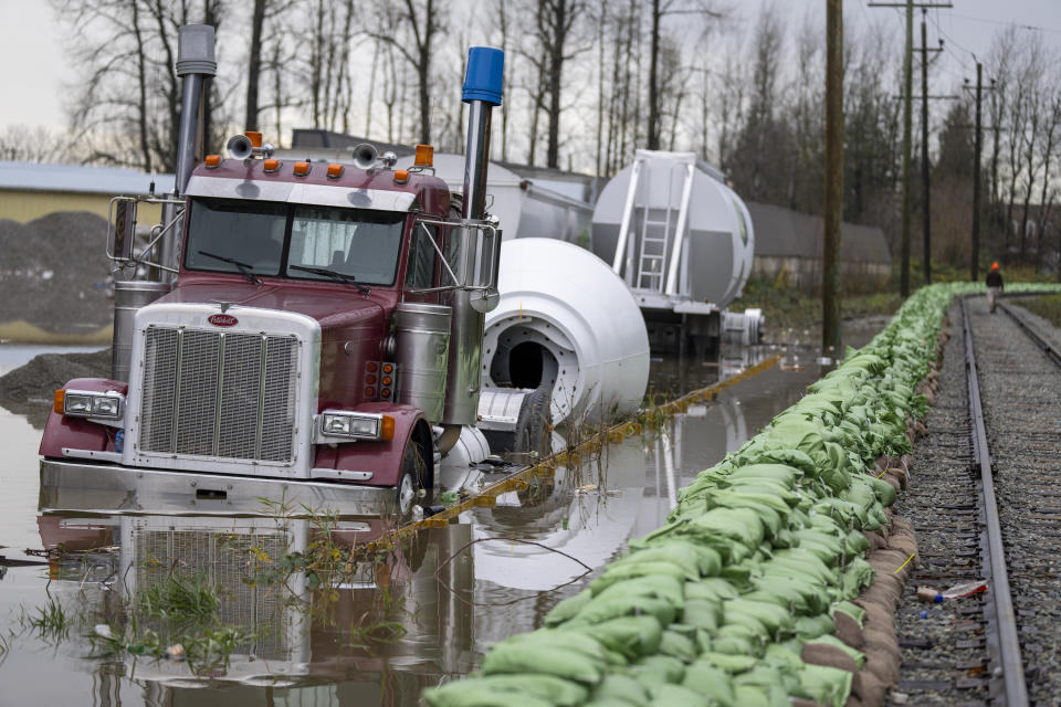 A truck gets swallowed up by rising floodwaters from the United States as waters cross the border into Abbotsford, British Columbia, Monday, Nov. 29, 2021. (Jonathan Hayward/The Canadian Press via AP)