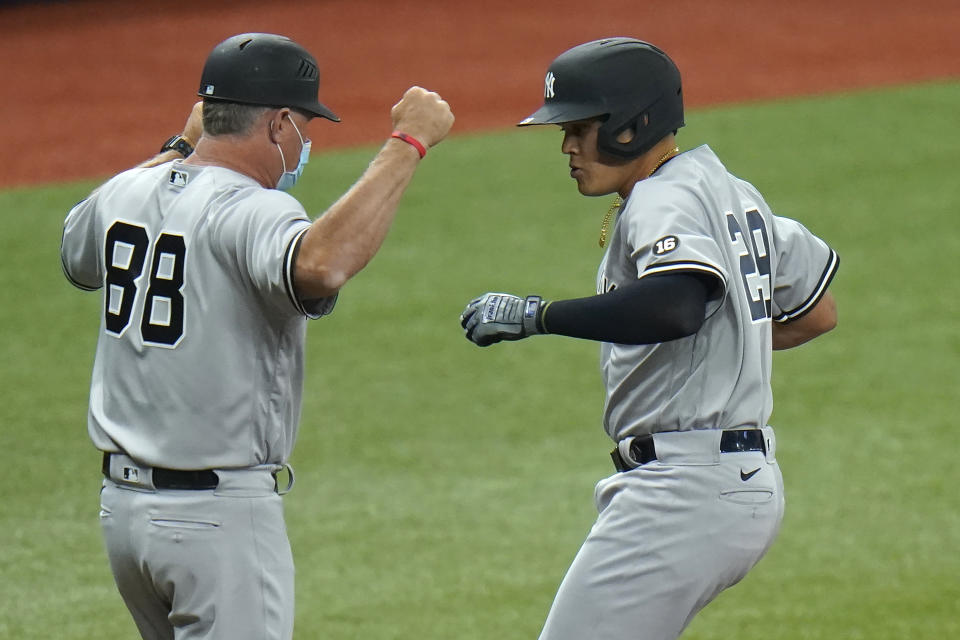 New York Yankees' Gio Urshela, right, celebrates his two-run home run off Tampa Bay Rays starting pitcher Michael Wacha with third base coach Phil Nevin during the third inning of a baseball game Sunday, April 11, 2021, in St. Petersburg, Fla. (AP Photo/Chris O'Meara)