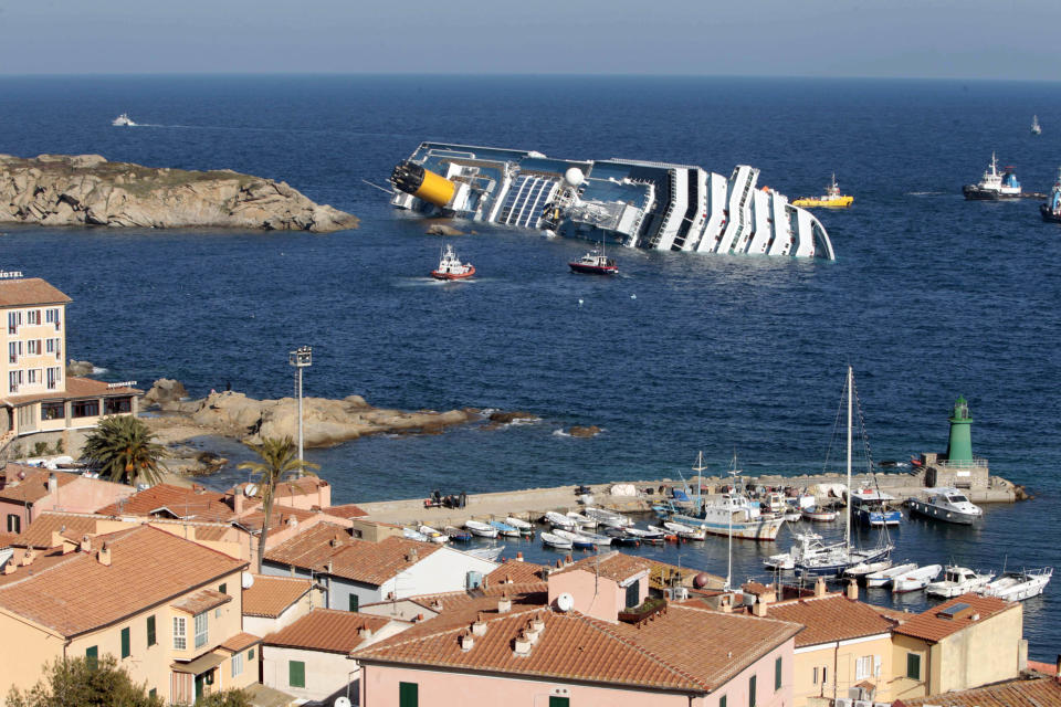 FILE - This Jan. 14, 2012 file photo shows the luxury cruise ship Costa Concordia leaning on its starboard side after running aground on the tiny Tuscan island of Giglio, Italy. During a press conference in Rome on Friday, Jan. 10, 2014, officials announced the shipwrecked Costa Concordia will be removed from its watery graveyard off Tuscany in June and taken to a port to be dismantled, the final phase of an unprecedented 600 million-euro ($817 million) salvage effort. The announcement came just days before the second anniversary of the Jan. 13, 2012, grounding that killed 32 people. (AP Photo/Gregorio Borgia, file)