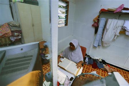 A Rohingya woman reads the Koran in her rented house in Cheras Baru, Kuala Lumpur March 2, 2014. REUTERS/Samsul Said