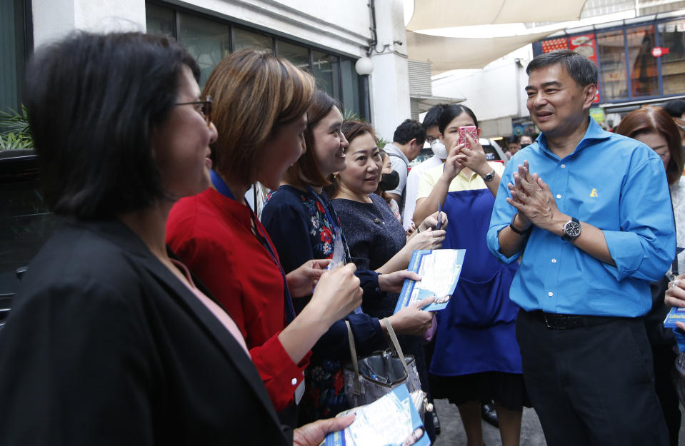 In this Tuesday, Jan. 29, 2019. the leader of Thailand's Democrat Party Abhisit Vejjajiva, right, gives the traditional greeting or "wai" during an election campaign neighborhood walk Bangkok, Thailand. Abhisit says if he becomes prime minister after Sunday’s election, he’ll make careful but forceful efforts to undo undemocratic constitutional clauses imposed by the military government that took power in 2014. (AP Photo/Sakchai Lalit)