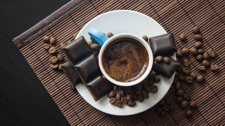 Coffee mug surrounded by chocolate 