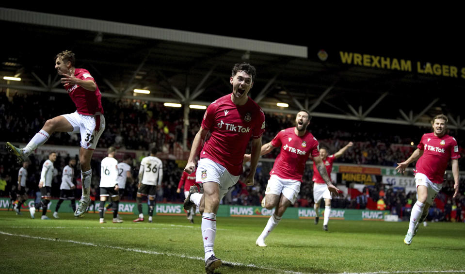 Wrexham's Tom O'Connor celebrates scoring against Sheffield United during the English FA Cup fourth round soccer match at The Racecourse Ground, Wrexham, Wales, Sunday Jan. 29, 2023. (Peter Byrne/PA via AP)