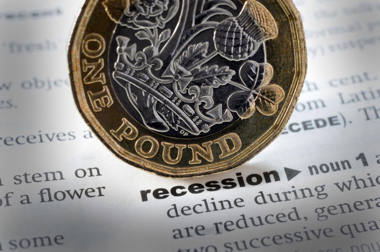 A pound coin sits above the dictionary definition of recession