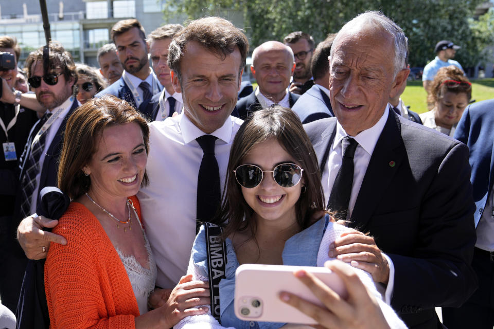 French President Emmanuel Macron and his Portuguese counterpart Marcelo Rebelo de Sousa, right, pose for a photo with well-wishers outside the venue hosting the United Nations Ocean Conference in Lisbon, Thursday, June 30, 2022. From June 27 to July 1, the United Nations is holding its Oceans Conference in Lisbon expecting to bring fresh momentum for efforts to find an international agreement on protecting the world's oceans. (AP Photo/Armando Franca)