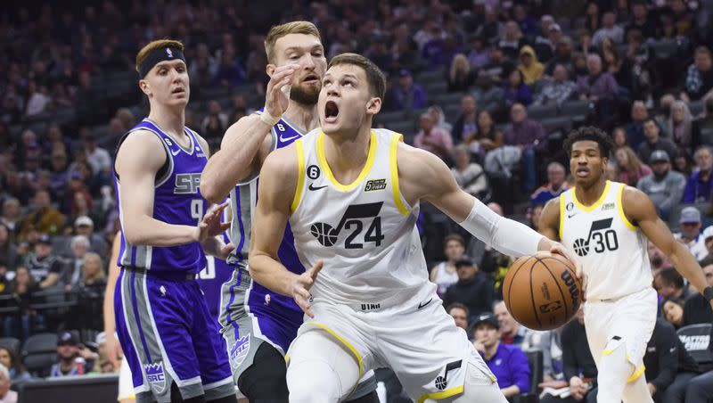 Utah Jazz center Walker Kessler (24) is guarded by Sacramento Kings guard Kevin Huerter, left, and forward Domantas Sabonis during the first quarter of an NBA basketball game in Sacramento, Calif., Saturday, March 25, 2023.