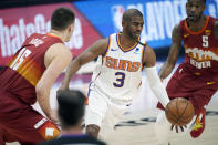 Phoenix Suns guard Chris Paul, center, drives to the rim between Denver Nuggets center Nikola Jokic, left, and forward Will Barton in the first half of Game 4 of an NBA second-round playoff series Sunday, June 13, 2021, in Denver. (AP Photo/David Zalubowski)
