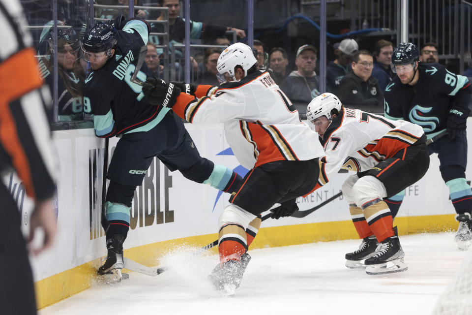 Anaheim Ducks defenseman Cam Fowler (4) checks Seattle Kraken center Ryan Donato (9) during the first period of an NHL hockey game Thursday, March 30, 2023, in Seattle. (AP Photo/Jason Redmond)