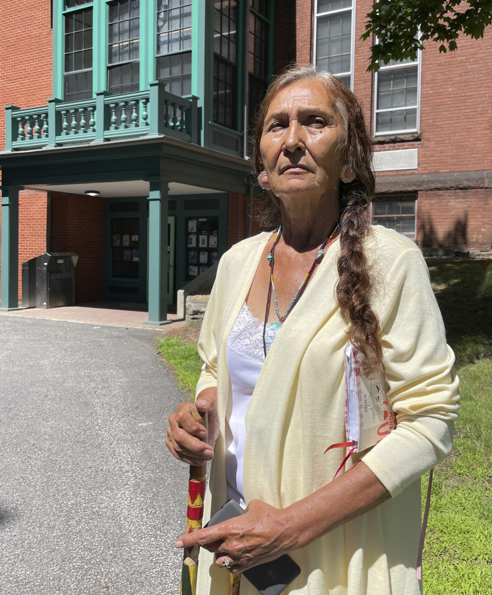 Leola One Feather, of the Oglala Sioux Tribe in South Dakota, stands outside the Woods Memorial Library on July 19, 2022 in Barre, Massachusetts. The library houses the Founders Museum, a private museum that is working to repatriate as many as 200 items believed to have been taken from Native Americans massacred by U.S. soldiers at Wounded Knee Creek in 1890. One Feather was among the tribe members overseeing the documentation of the items ahead of their expected return. (AP Photo/Philip Marcelo)