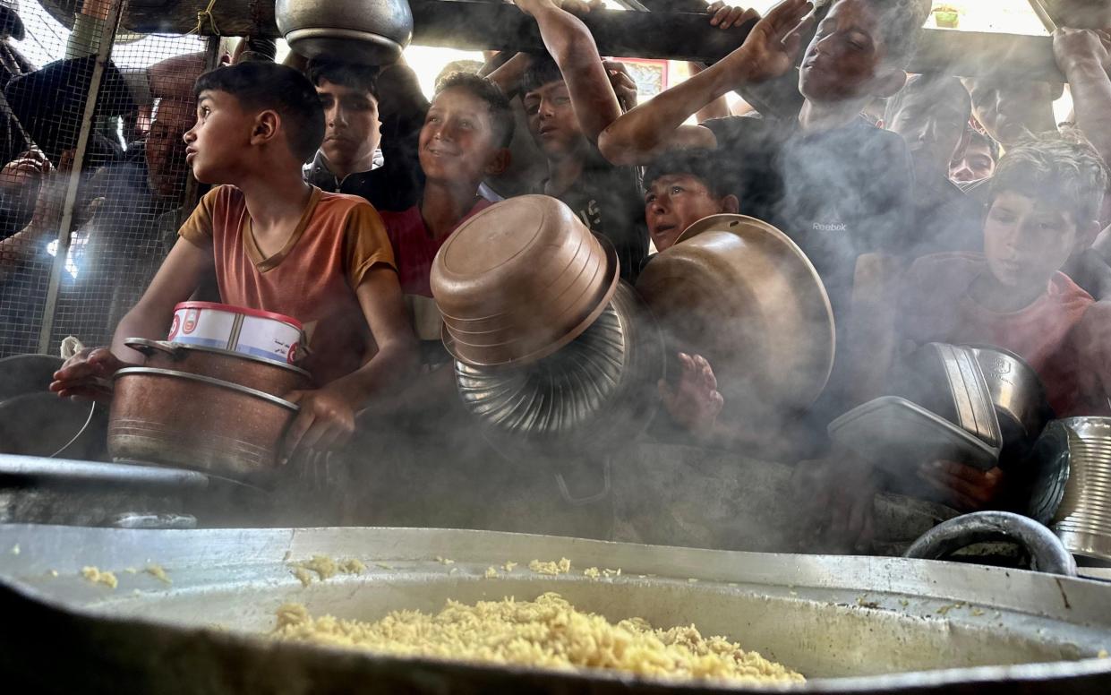 Children in Rafah city queue to receive a bowl of food for their families from charity organizations, in Rafah, southern Gaza on May 03 2024.