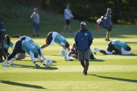 Brian Flores Head Coach of the Miami Dolphins walks amongst his players during a practice and media availability by the Miami Dolphins In Ware, England, Friday, Oct. 15, 2021. The Dolphins play the Jaguars in a regular season NFL game on Sunday at Tottenham Hotspurs White Hart Lane stadium in London. (AP Photo/Alastair Grant)