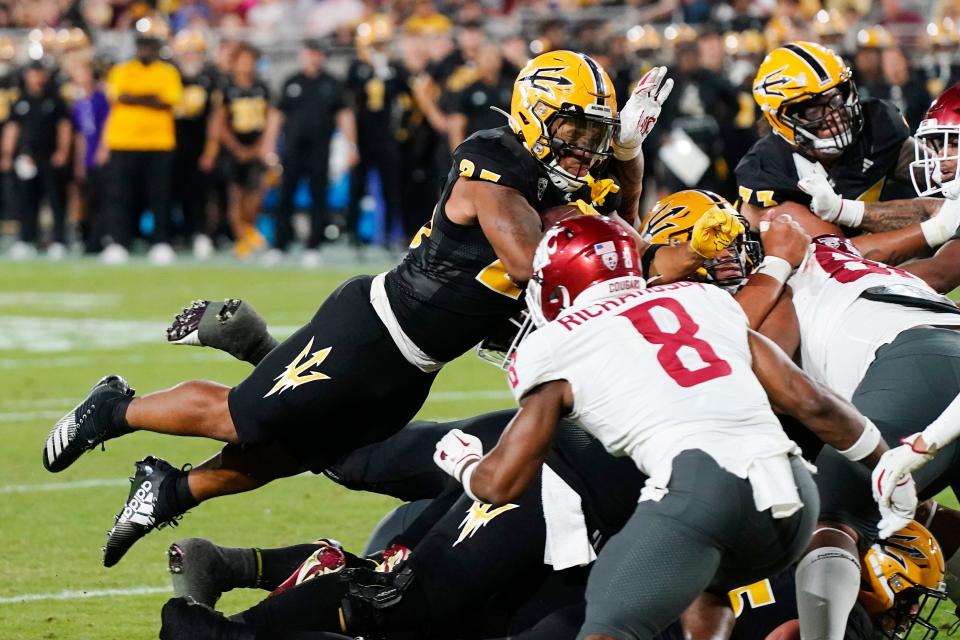Arizona State running back DeCarlos Brooks, left, leaps into the end zone for a touchdown as Washington State linebacker Devin Richardson (8) arrives late during the first half of an NCAA college football game Saturday, Oct. 28, 2023, in Tempe, Ariz. (AP Photo/Ross D. Franklin)