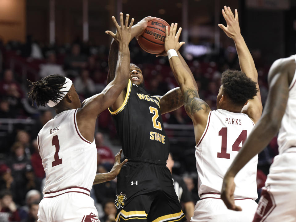 Wichita State's Jamarius Burton (2) shoots as Temple Quinton Rose (1) and Arashma Parks (14) defend during the first half of an NCAA college basketball game Wednesday, Jan. 15, 2020, in Philadelphia. (AP Photo/Michael Perez)