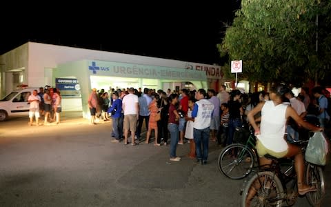 People wait for news outside Janauba's hospital - Credit: AFP