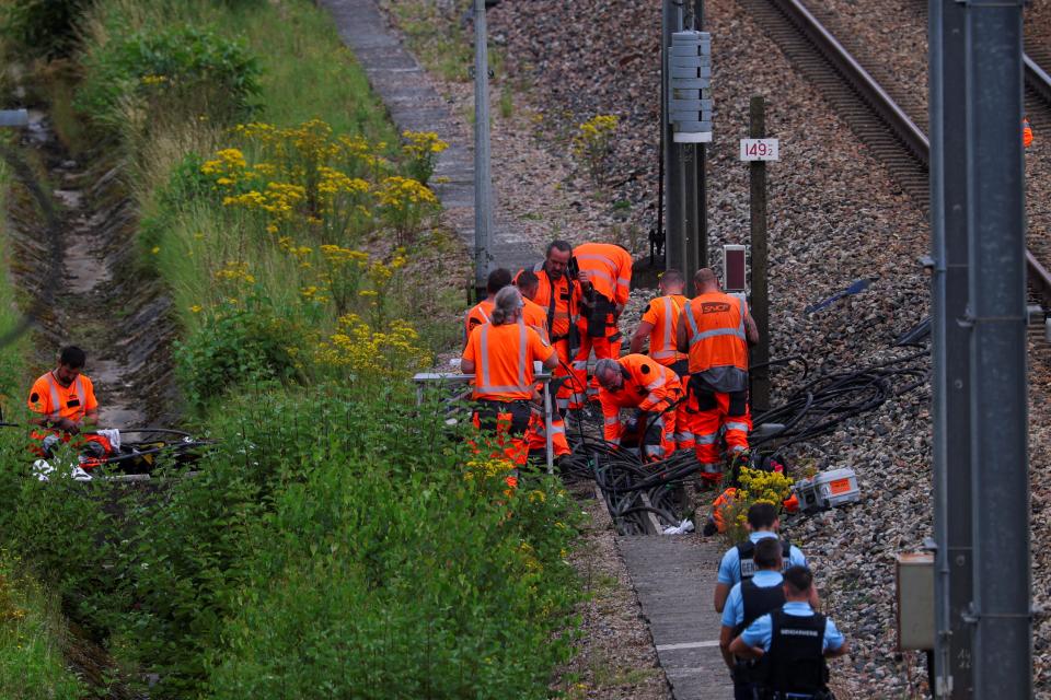 Railway staff work on a train line after it was sabotaged by arson ahead of the Paris Olympics opening ceremony