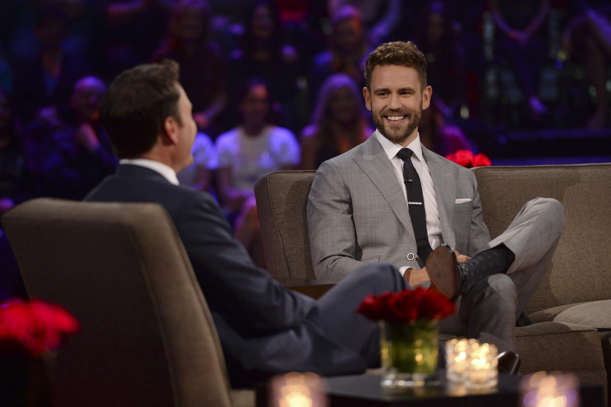 Nick Viall sitting on a couch in front of an audience.