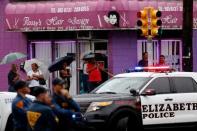 Onlookers watch while Federal Bureau of Investigation (FBI) personnel search an address during an investigation into Ahmad Khan Rahami, who was wanted for questioning in an explosion in New York, which authorities believe is linked to the explosive devices found in New Jersey, in Elizabeth, U.S., September 19, 2016. REUTERS/Eduardo Munoz