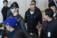 Los Angeles Dodgers manager Dave Roberts, center, walks with security during the baseball team's arrival at Incheon International Airport, Friday, March 15, 2024, in Incheon, South Korea, ahead of the team's baseball series against the San Diego Padres. (AP Photo/Ahn Young-joon)