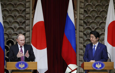 Russian President Vladimir Putin speaks as Japanese Prime Minister Shinzo Abe listens during a joint news conference in Tokyo, Japan, December 16, 2016. REUTERS/Alexander Zemlianichenko/Pool
