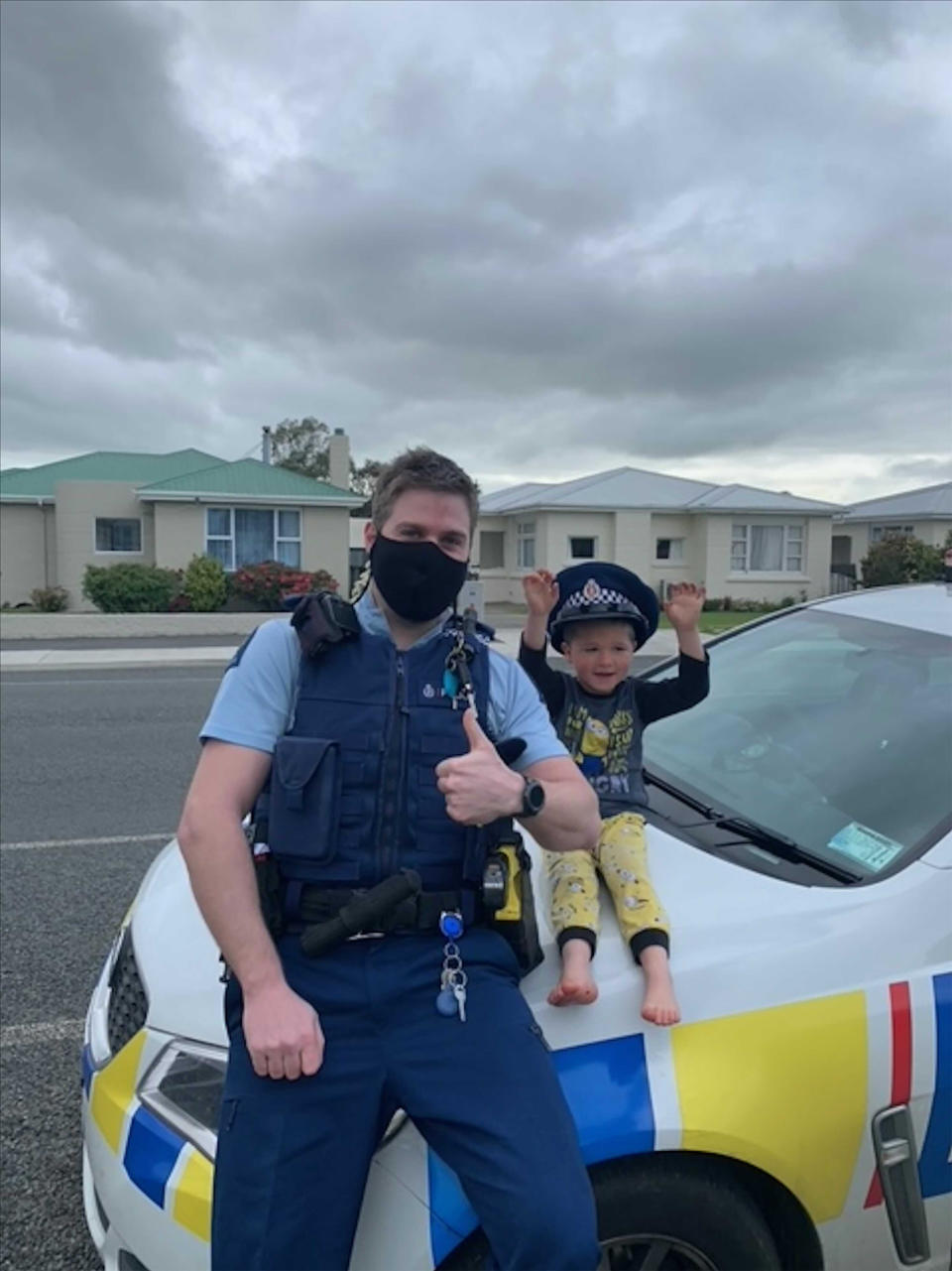 In this photo released by New Zealand Police, an officer identified only as Constable Kurt sits on his patrol car with a 4-year-old boy who is not identified, in the South Island city of Invercargill, New Zealand, Friday, Oct. 15, 2021. An emergency call made by the 4-year-old New Zealand boy asking for police to come over and check out his toys prompted a real-life callout and confirmation from an officer that the toys were, indeed, pretty cool. (NZ Police via AP)