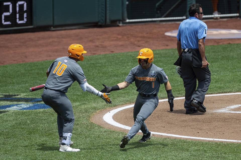 Tennessee's Drew Gilbert (1) celebrates scoring with teammate Pete Derkay (10) in the second inning against Texas during a baseball game in the College World Series Tuesday, June 22, 2021, at TD Ameritrade Park in Omaha, Neb. (AP Photo/John Peterson)