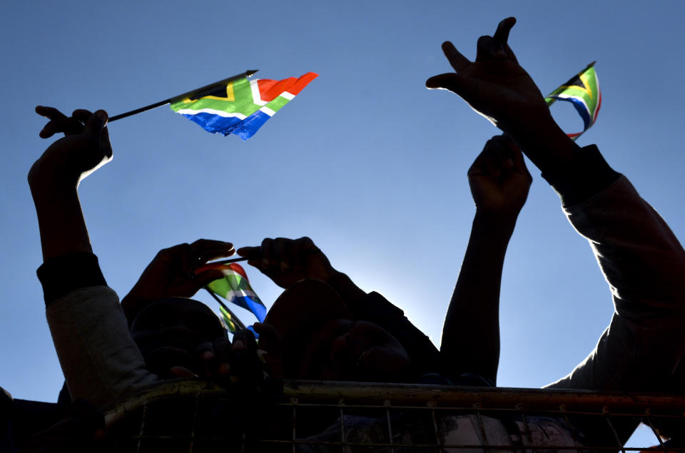 People hold South African flags as they attend 20-year Democracy Anniversary celebrations at the government's Union Building in Pretoria, South Africa, Sunday, April 27, 2014. The day marks the end of the apartheid era when all races went to the polls to cast their votes in historic 1994 elections. (AP Photo)