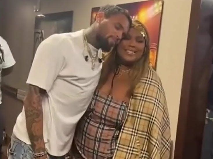 Chris Brown and Lizzo pose for a photo together.