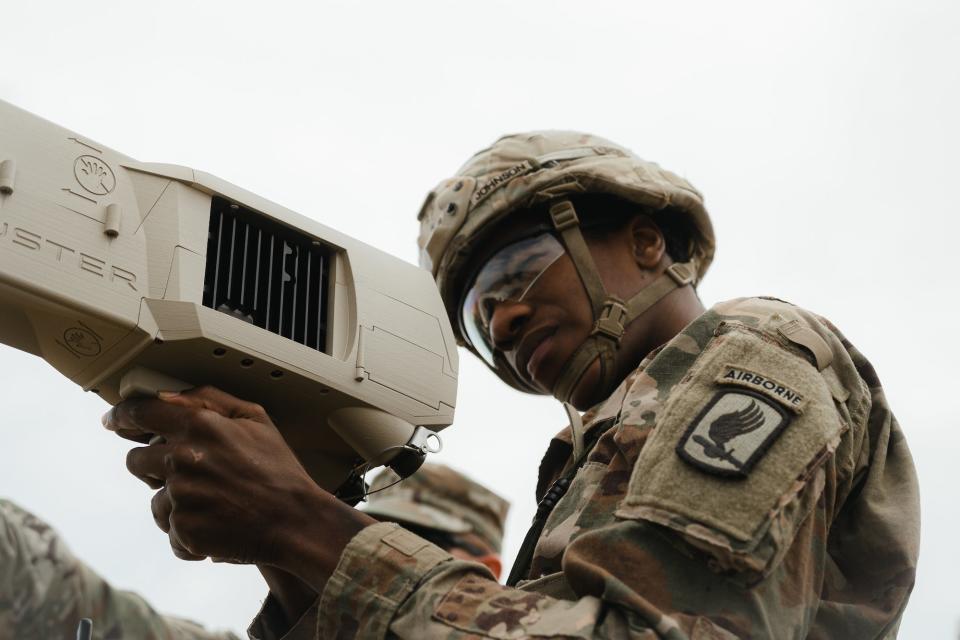 Another soldier sights down a drone with the Dronebuster.