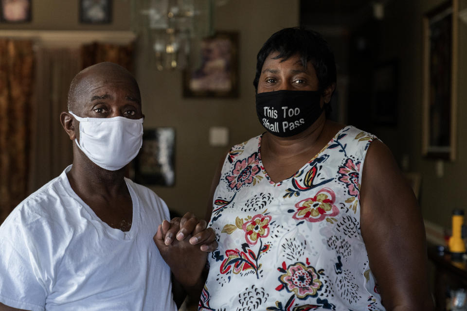 Mary and Barrett Duplessis pose for a portrait in their home in New Orleans, Wednesday, Aug. 19, 2020. Levee breaches following Hurricane Katrina dumped 6 feet of water into the home of Mary Duplessis and her husband in 2005. She remembers lots of paperwork and bureaucracy in her Katrina recovery, and she recalls the scenes of misery at a convention center where thousand were trapped without power or running water. But, for her, COVID-19, has been worse. (AP Photo/Gerald Herbert)