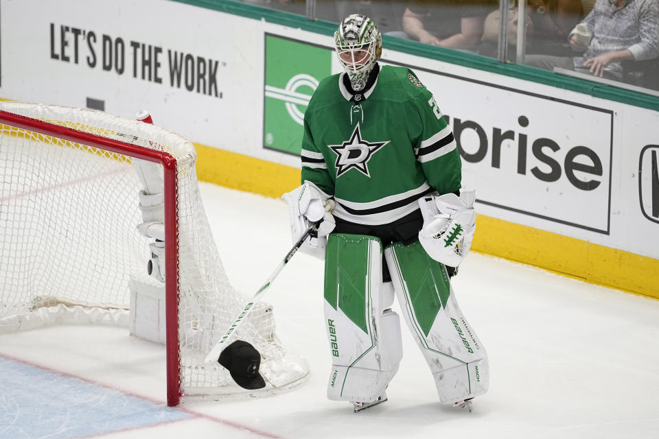 Dallas Stars goaltender Jake Oettinger (29) carries a cap on the end of his stick that was tossed onto the ice after Roope Hintz scored his third goal of the game in the third period of Game 2 of an NHL hockey Stanley Cup first-round playoff series against the Minnesota Wild, Wednesday, April 19, 2023, in Dallas. (AP Photo/Tony Gutierrez)