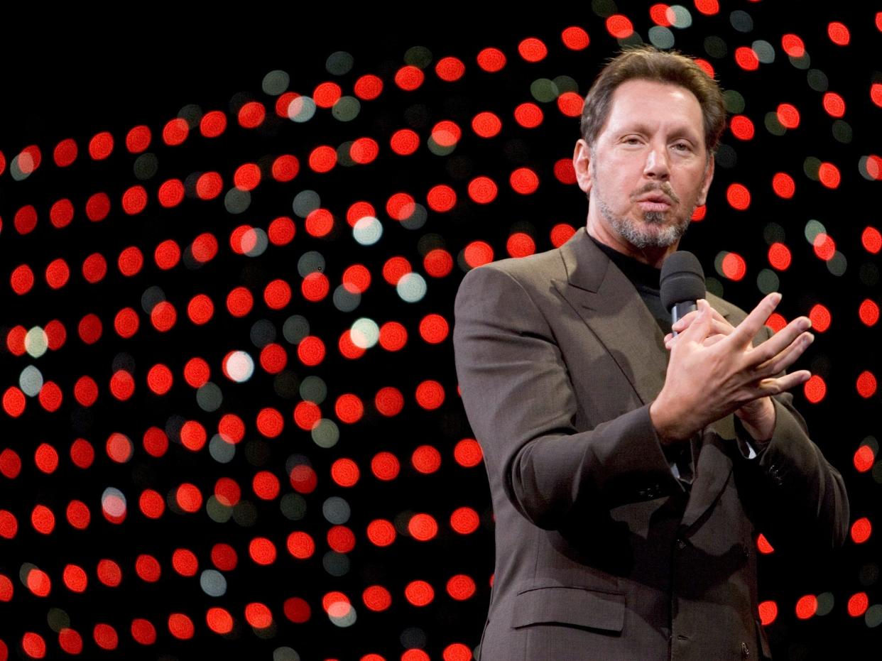 Larry Ellison, Oracle cofounder, speaks onstage in front of background of red circles