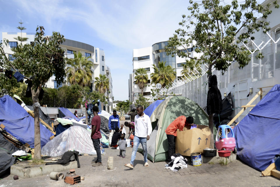 FILE - Migrants walk in a makeshift camp outside the International Organization for Migration office, on March 31, 2023 in Tunis. A meeting this week in Tunis of human rights activists from North Africa, west Africa and Europe denounced a summit meeting on migration this Sunday in Rome, saying its goal is to pursue an anti-migrant vision and put the onus on Africa to keep European borders safe from African arrivals. (AP Photo/Hassene Dridi, File)