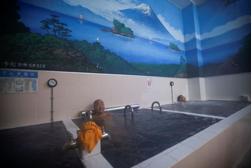 People soak in bathtubs at a Japanese public bathhouse in Tokyo