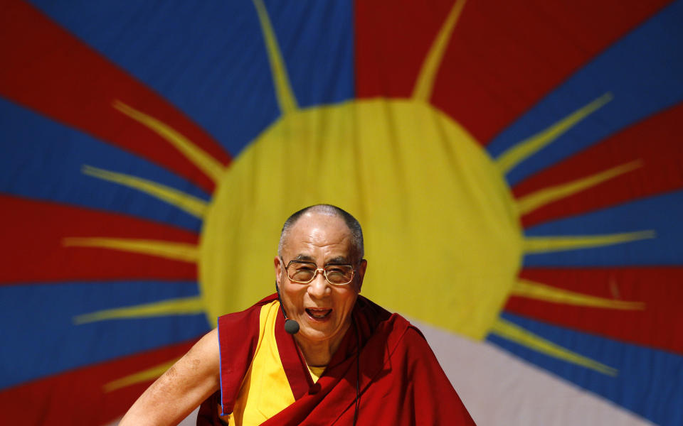 FILE - In this Nov. 27, 2012 file photo, Tibetan spiritual leader the Dalai Lama laughs as he addresses Tibetan exiles living in Bangalore, in front of the Tibetan flag, in Bangalore, India. The Dalai Lama is set to headline India's Jaipur Literature Festival to speak about faith with one of his biographers, Pico Iyer. The Tibetan spiritual leader will hold a session on the festival's first day, Thursday, Jan. 24, 2013, titled: "Kinships of Faiths: Finding the Middle Way." (AP Photo/Aijaz Rahi, File)