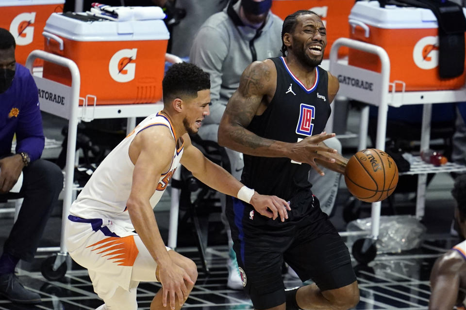 Los Angeles Clippers forward Kawhi Leonard, right, is defended by Phoenix Suns guard Devin Booker during the first half of an NBA basketball game Thursday, April 8, 2021, in Los Angeles. (AP Photo/Marcio Jose Sanchez)