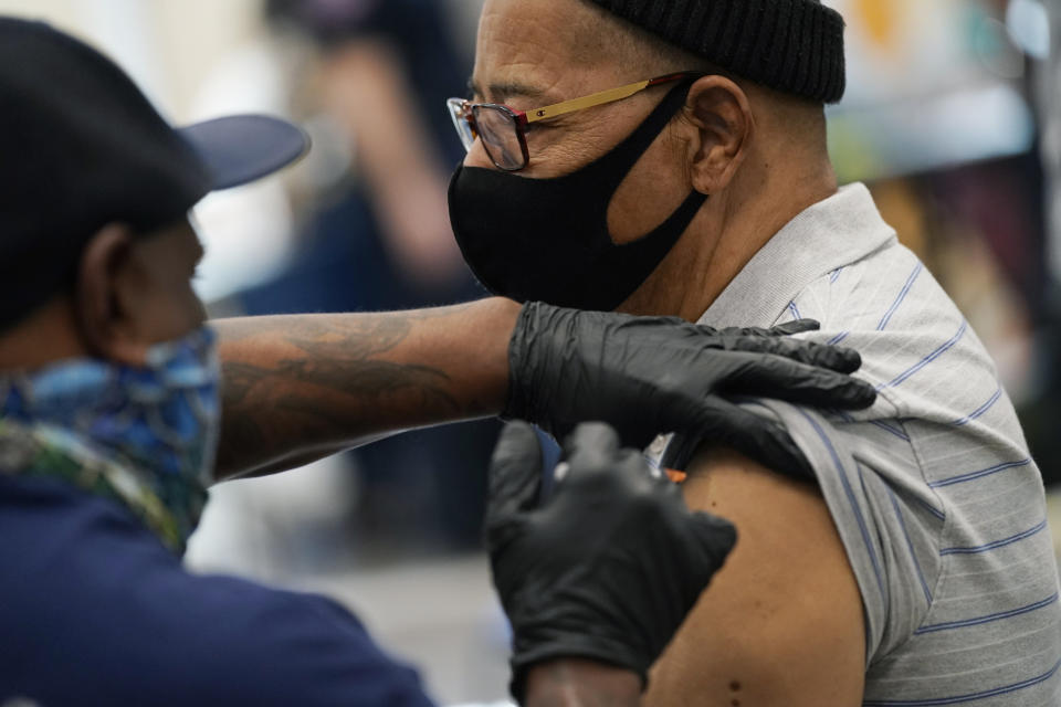 Wayne Pollard receives a COVID-19 vaccine at the Martin Luther King Senior Center, Wednesday, Feb. 10, 2021, in North Las Vegas. The "pop-up" clinic was held to serve under-vaccinated areas in Las Vegas. (AP Photo/John Locher)