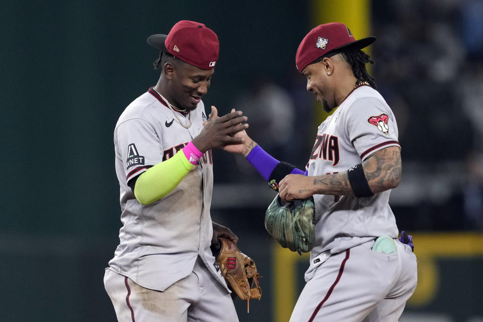 Arizona Diamondbacks' Geraldo Perdomo, left, and Ketel Marte celebrate after Game 2 of the baseball World Series against the Texas Rangers Saturday, Oct. 28, 2023, in Arlington, Texas. The Diamondbacks won 9-1. (AP Photo/Godofredo A. Vásquez)