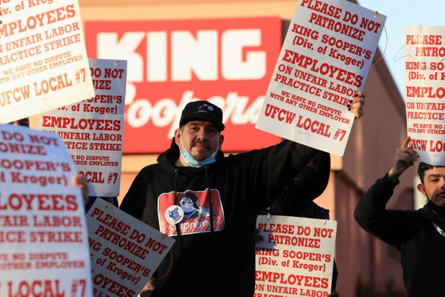 Union members raise signs outside a King Soopers store during a protest on Jan. 12. (Photo: Kevin Mohatt via Reuters)