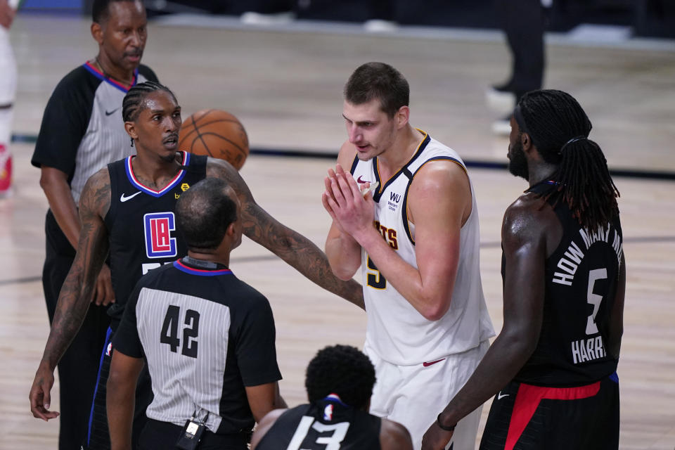 Denver Nuggets center Nikola Jokic, center, questions a call during the second half of an NBA conference semifinal playoff basketball game against the LA Clippers, Tuesday, Sept. 15, 2020, in Lake Buena Vista, Fla. (AP Photo/Mark J. Terrill)
