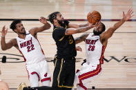 Los Angeles Lakers forward Anthony Davis shoots between Miami Heat forward Jimmy Butler, left, and guard Andre Iguodala during the second half in Game 5 of basketball's NBA Finals Friday, Oct. 9, 2020, in Lake Buena Vista, Fla. (AP Photo/John Raoux)