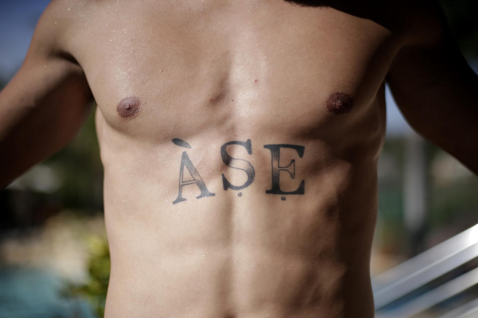 Paulinho of Brazil´s Atletico Mineiro poses for a photo showing his new tattoo that reads "Áse," or energy in the Yoruba language, which is key to the Candomblé religion, at his home in Belo Horizonte, Brazil, Sunday, Sept. 17, 2023. Paulinho showed his pride in Candomblé during a game after scoring a goal when he took off his shirt, displaying the tattoo for the first time. (AP Photos/Thomas Santos)