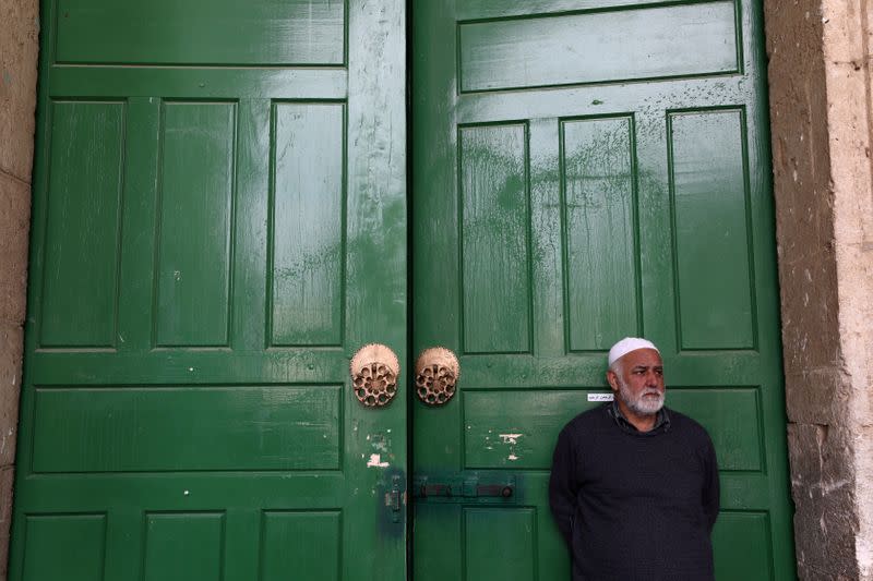 FILE PHOTO: An employee of the Islamic Waqf stands in front of the closed doors of Al-Aqsa mosque