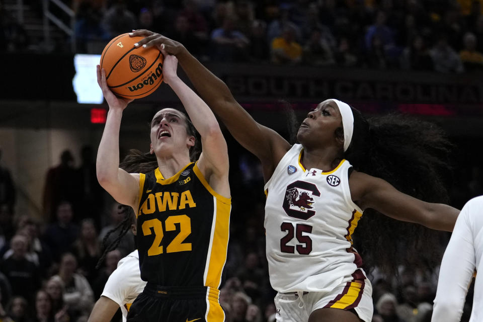 South Carolina guard Raven Johnson (25) blocks a shot by Iowa guard Caitlin Clark (22) during the first half of the Final Four college basketball championship game in the women's NCAA Tournament, Sunday, April 7, 2024, in Cleveland. (AP Photo/Carolyn Kaster)