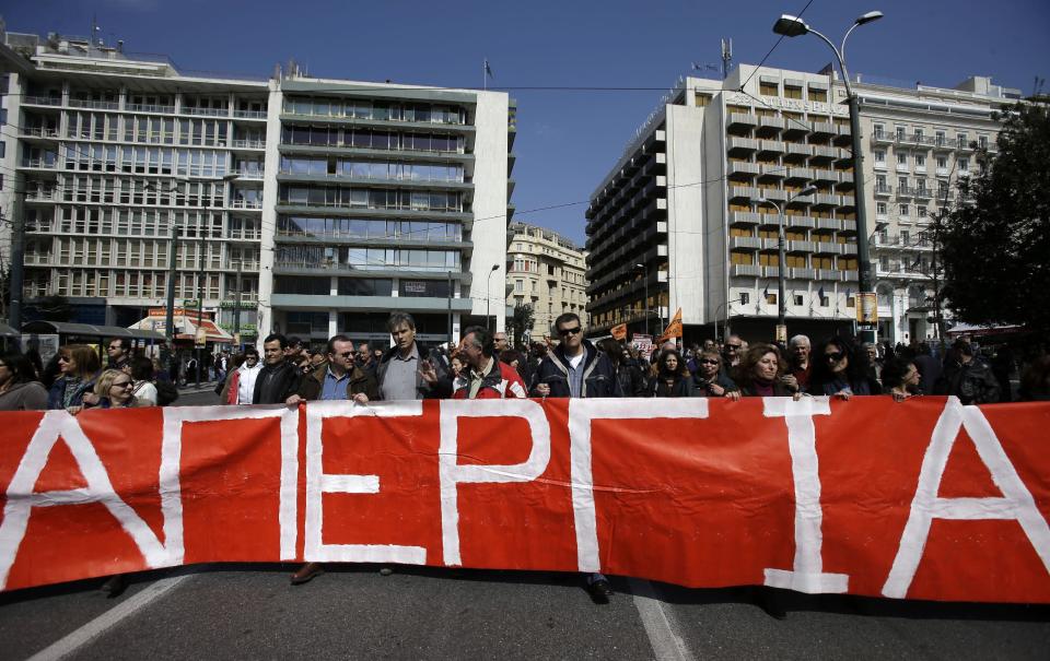 Protesters hold a banner reading ''Strike'' during a rally in Athens on Wednesday, March 12, 2014. A 24-hour strike by civil servants disrupted public services in Greece Wednesday as the country’s government struggled to hammer out a deal on further austerity measures with international creditors. Thousands of protesters attended rallies in Athens and other Greek cities, while civil servants have penciled in another 48-hour strike on March 19-20. (AP Photo/Thanassis Stavrakis)