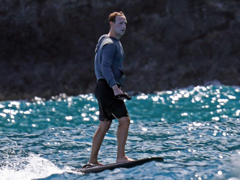 Mark Zuckerberg rides an electric hydrofoil surfboard off the coast of Kauaʻi while wearing a visible coat of sunscreen on his face.