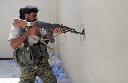 A member of the Syrian Democratic Forces widens the hole in the wall during the fighting with Islamic State in Al Senaa, a district of Raqqa, Syria, August 10, 2017. REUTERS/Zohra Bensemra