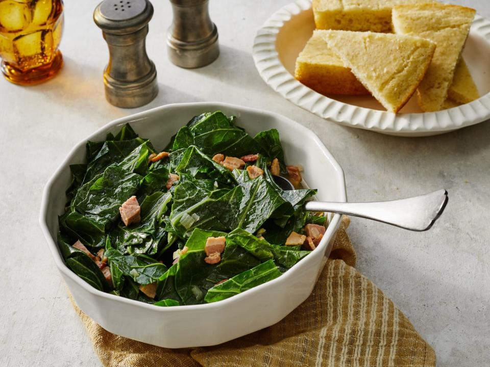 Southern-Style Collard Greens in a white bowl with a bowl of cornbread beside it