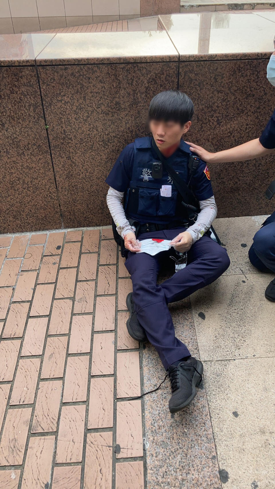 台北市消防局22日下午獲報在台北車站南二門附近有人受傷，人員到場發現為2名員警受傷，其中1人脖子有7公分割傷。兩人是在盤查一名未戴口罩男子時遭持刀割傷，該男隨後也被壓制，帶回警局偵辦。（中央社／警方提供）