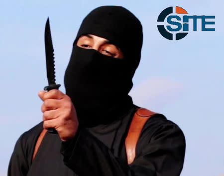 A masked, black-clad militant, who has been identified by the Washington Post newspaper as a Briton named Mohammed Emwazi, brandishes a knife in this still image from a 2014 video obtained from SITE Intel Group February 26, 2015. REUTERS/SITE Intel Group/Handout via Reuters